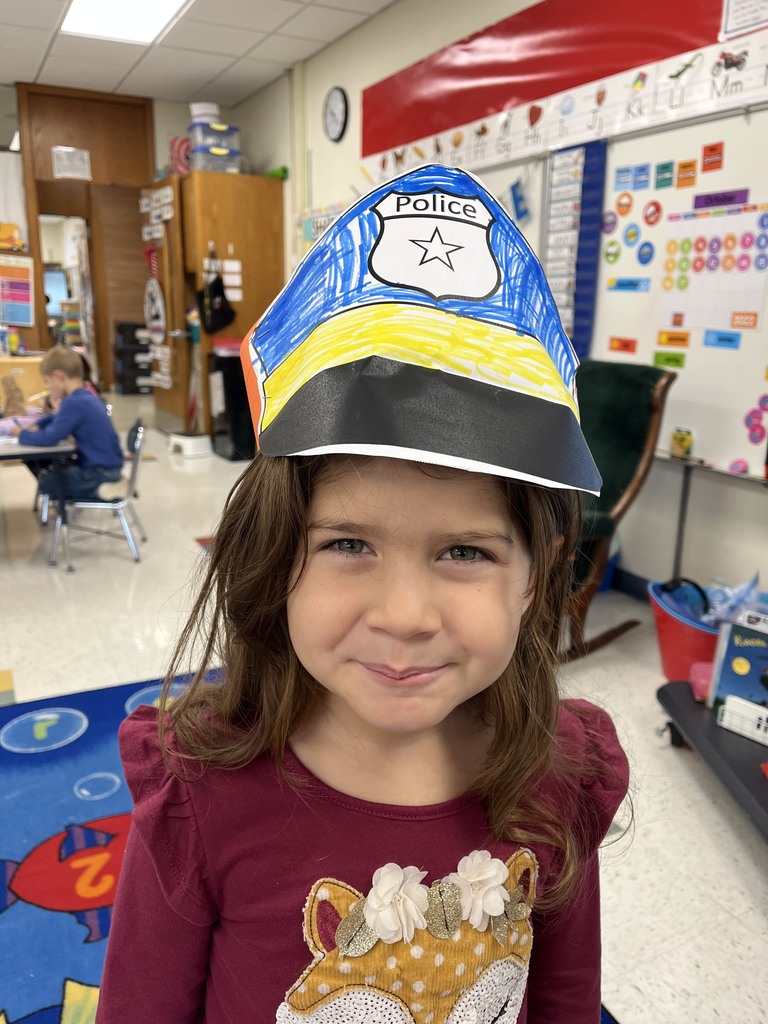 Kindergarten student wearing a hand-made paper police hat